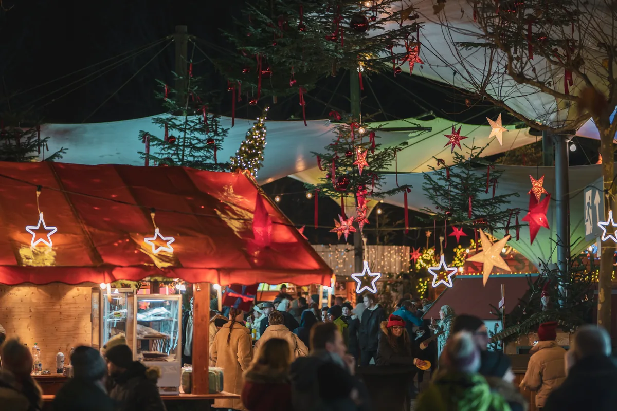 Festlich beleuchteter Stadtgarten mit Christbaum Sch&auml;nke und F&uuml;xle Bar