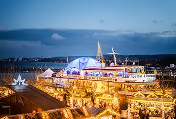 Weihnachtsmarkt am See mit H&uuml;tten und Bodensee